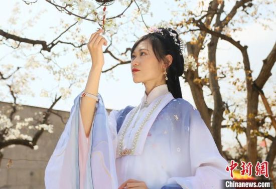 圖為蘭州青年身穿漢服在百年梨園賞景?！「哒?攝