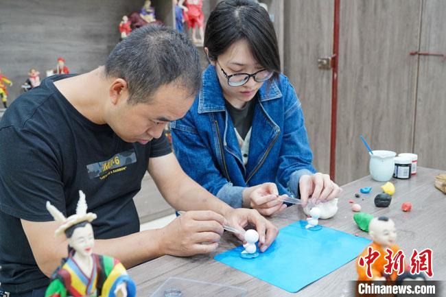 <a target='_blank'  data-cke-saved- >中新社</a>記者(右)現(xiàn)場(chǎng)體驗(yàn)面塑制作過(guò)程。　陳爭(zhēng)強(qiáng) 攝