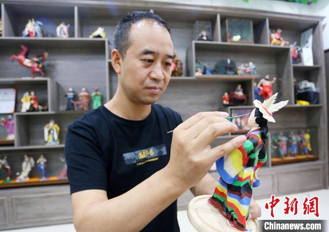 圖為安秋平正在創(chuàng)作代表隴南文縣民俗的《白馬人》作品?！「哒?攝