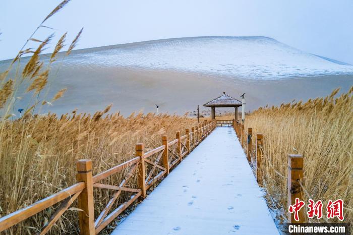 2021年11月28日，在敦煌鳴沙山月牙泉景區(qū)，沙雪交融，更顯北國風(fēng)情?！⊥醣筱y 攝