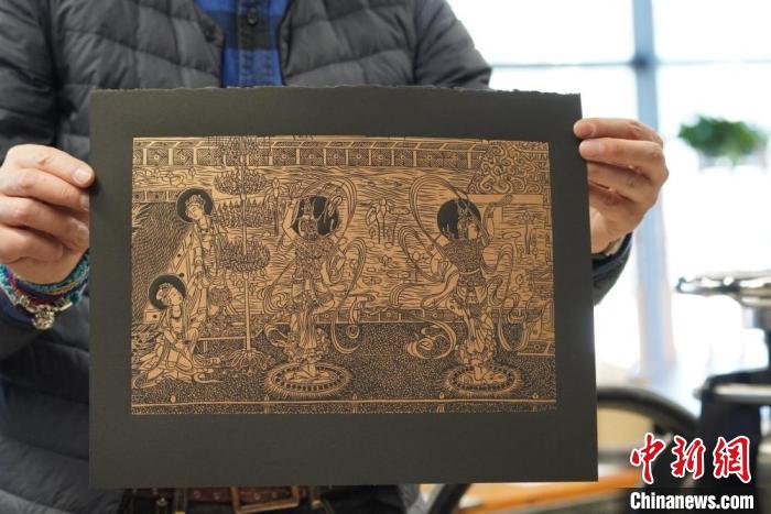 圖為手工書藝人展示敦煌雕版壁畫印刷品?！【琶赖┰?　攝