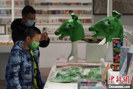 圖為“神馬來了”銅奔馬頭套吸引參觀者駐足?！【琶赖┰?攝