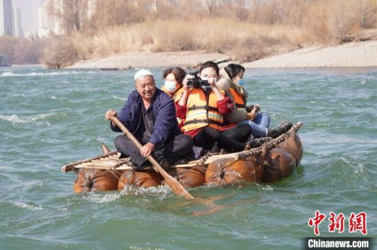 2月24日，年過(guò)七旬的蘭州羊皮筏子制作技藝第三代傳承人張德寶在黃河上劃著羊皮筏子。(資料圖) 九美旦增 攝