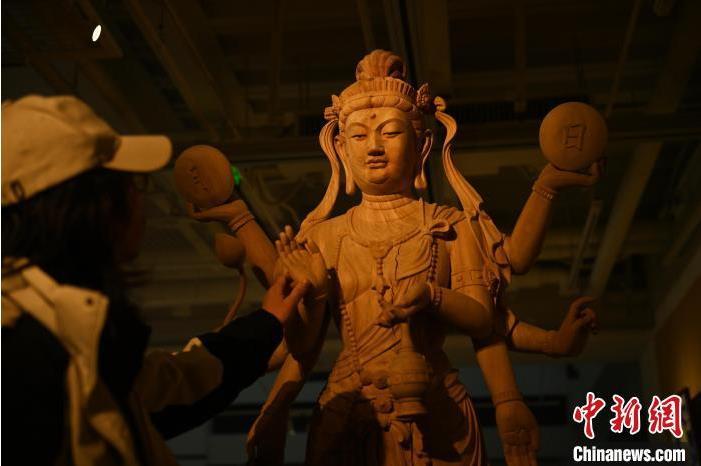 圖為季茂杰觀察自己創(chuàng)作的敦煌木雕。李亞龍 攝</p>
<p>