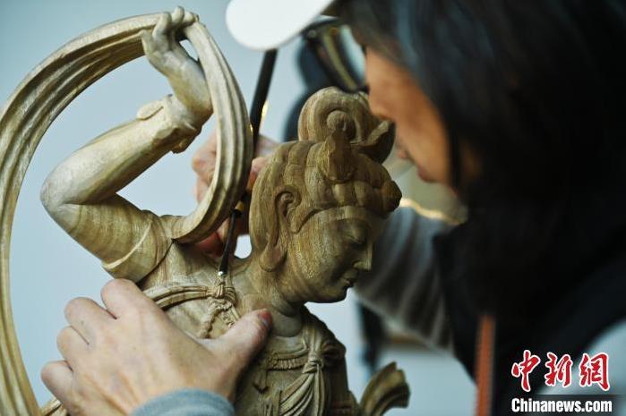 圖為季茂杰進(jìn)行敦煌元素的木雕創(chuàng)作。李亞龍 攝</p>
<p>